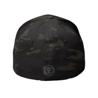 Back view of the multicam black Flexfit Men's Cap with a small outlined light-gray circular cross logo at the nape, product shot on white.