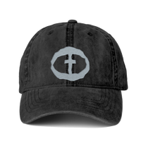 Front view of the washed-black Cassie Women's Ponytail Cap with a light-gray embroidered circular cross logo, product shot on white.