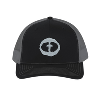 Front view of the black-and-charcoal Richardson 112 Cap with a light-gray circular cross logo on the front panel, product shot on white.
